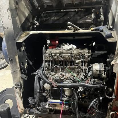 An in-chassis engine rebuild with the valve covers off, exposing the rocker assembly, injectors and alternator.