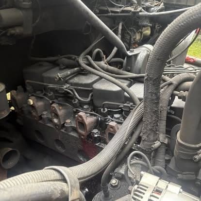 The top end of a diesel engine with the valve cover removed, showing the injectors and pushrod tubes.