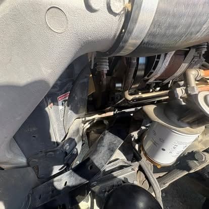 The fuel filter housing and water separator mounted under the cab of a heavy truck.