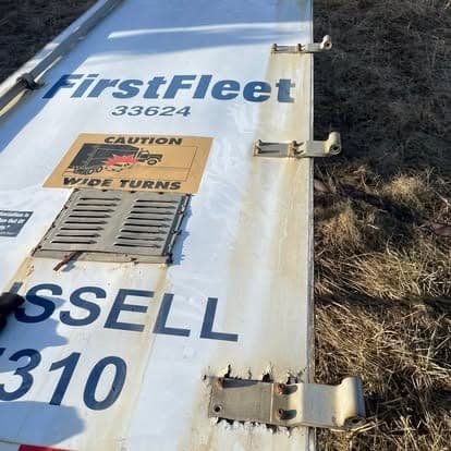 A repaired trailer side panel laid out with new hinges and hardware fitted before it goes back on.